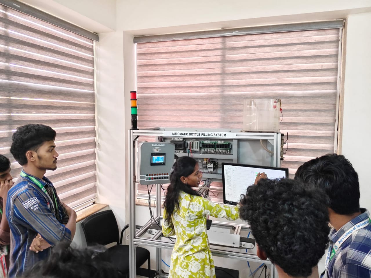 Trainer walking a group of students through the automatic bottle-filling system in the Infercon lab